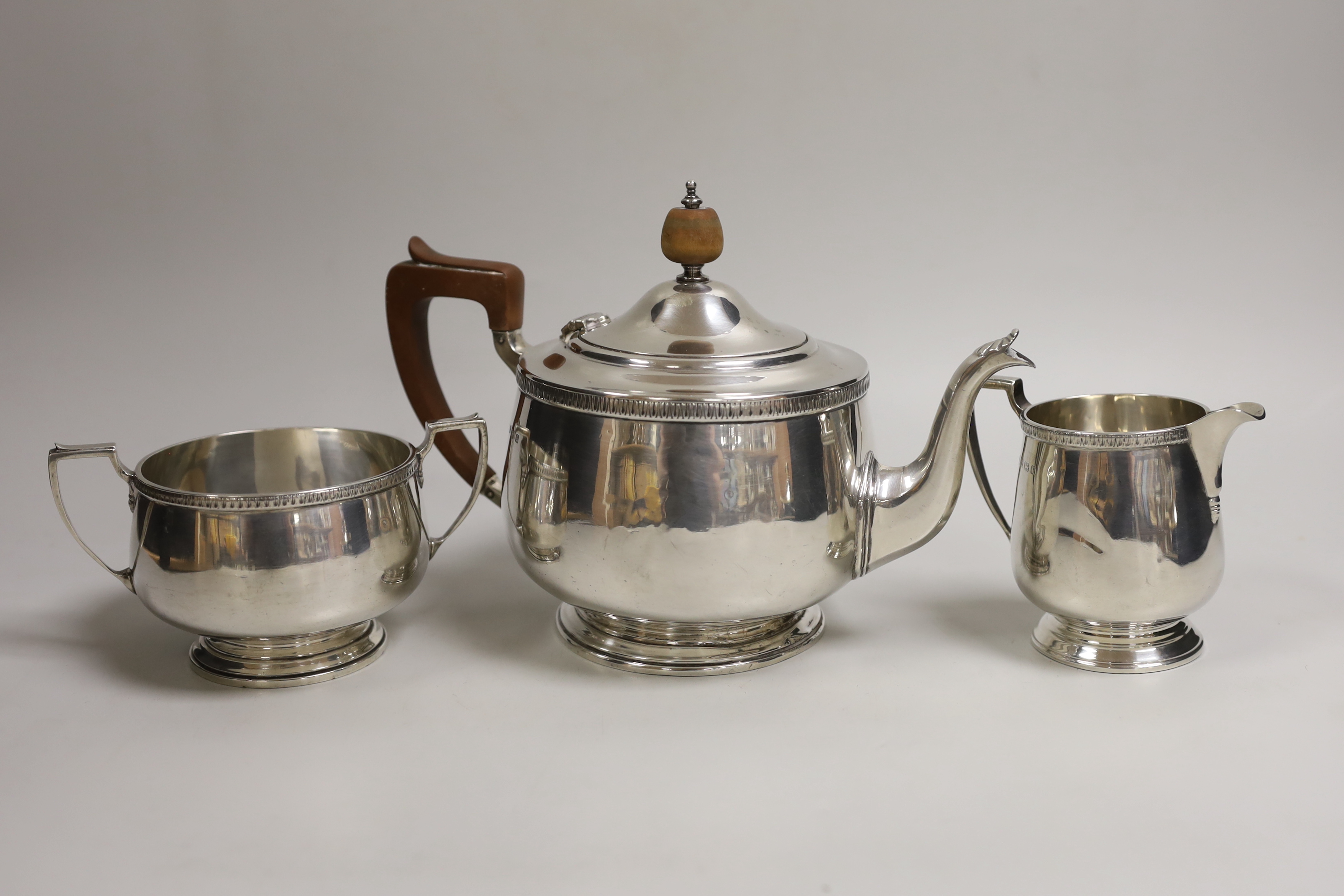 A George V silver circular three piece tea set, Alexander Clark Co, Birmingham, 1930, gross weight 26.3oz.